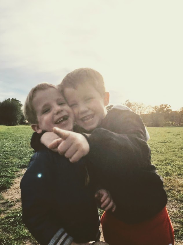 Twee jongens met de armen om elkaar heen in de zon